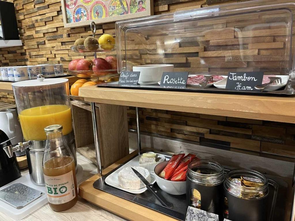 a breakfast bar with a drink and some food at Hotel Best Western La Mare Ô Poissons in Ouistreham