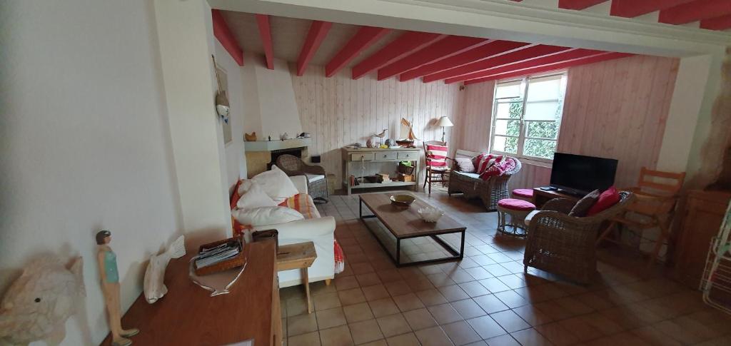 a living room with a couch and a table at Maison Hortensias Fromentine 8 pers près de la plage in La Barre-de-Monts