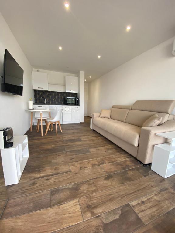 un salon avec un canapé et une cuisine dans l'établissement Studio neuf avec terrasse vue mer, à Cannes