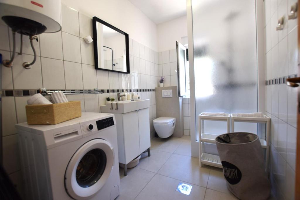 łazienka z pralką i toaletą w obiekcie Holiday Home Movica w mieście Mandre
