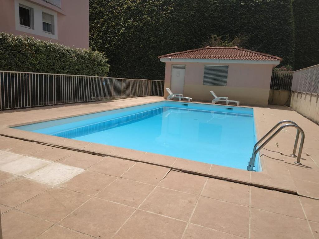 une grande piscine dans une cour avec dans l'établissement Studio avec coin nuit et garage, à Saint-Laurent-du-Var