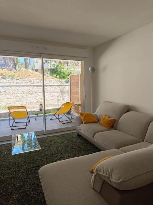 un salon avec un canapé, une table et des chaises dans l'établissement T2 neuf avec terrasse proche Avignon, à Villeneuve-lès-Avignon