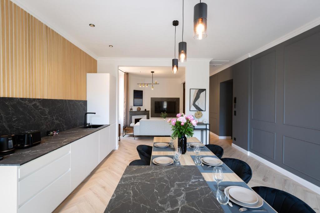 a kitchen and living room with a long dining table at L'Oranger T4 Elegant and bright Prime Location in Grasse