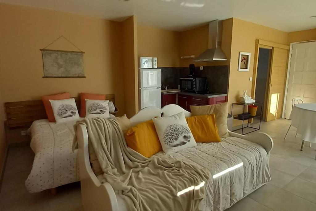 une chambre avec un lit avec des oreillers dessus dans l'établissement Studio privatif, à Lespignan