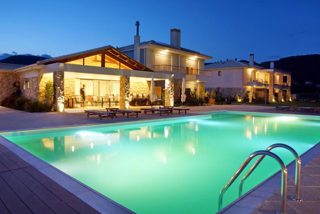 a swimming pool in front of a house at night at Cavos Fokidos in Chiliadou