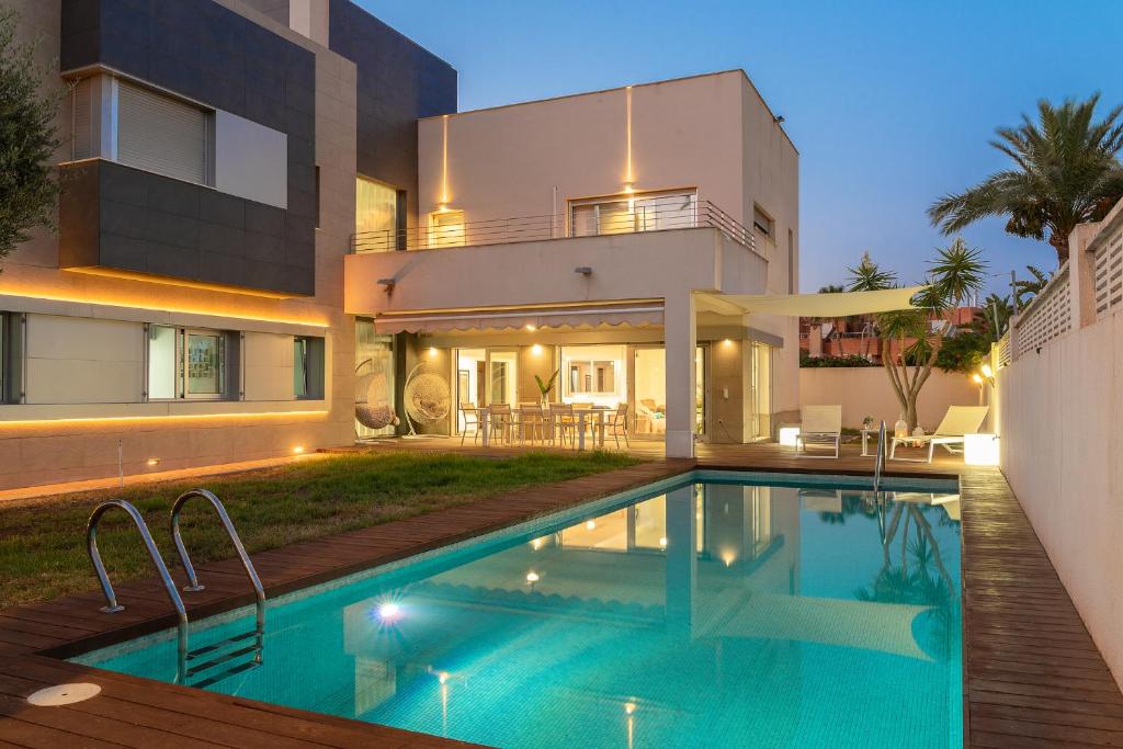 a house with a swimming pool in front of a house at Villa Helios Aguadulce Almeria in Roquetas de Mar