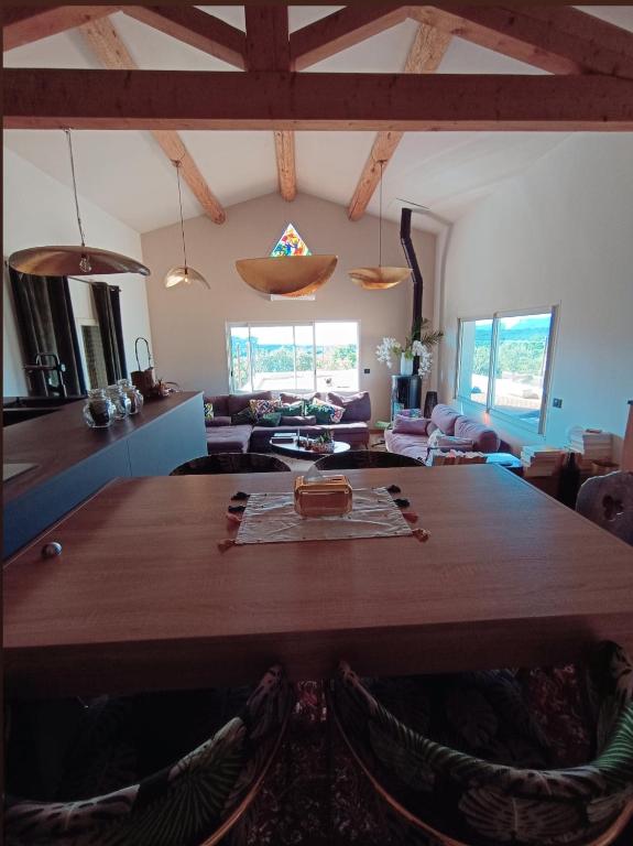 a living room with a large wooden table with chairs at Là où le Ciel est né Beau mas pierres et contemporain sur grande propriété vue Mont Ventoux dentelles de Montmirail in Blauvac