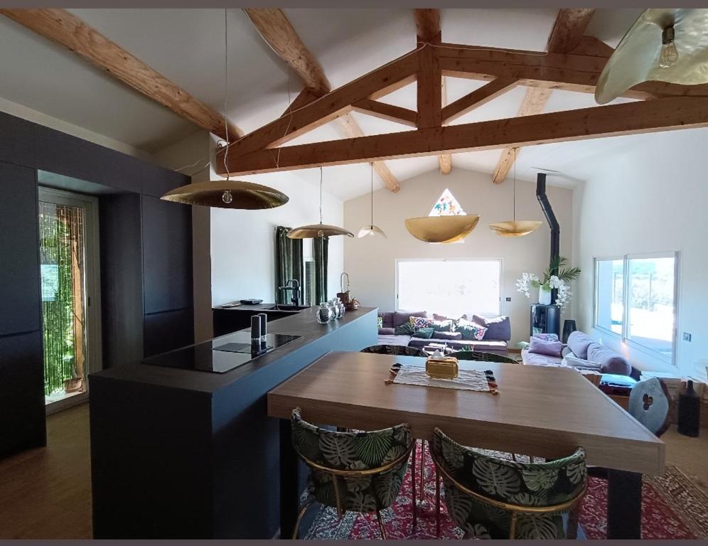 a kitchen and living room with a table and chairs at Là où le Ciel est né Beau mas pierres et contemporain sur grande propriété vue Mont Ventoux dentelles de Montmirail in Blauvac
