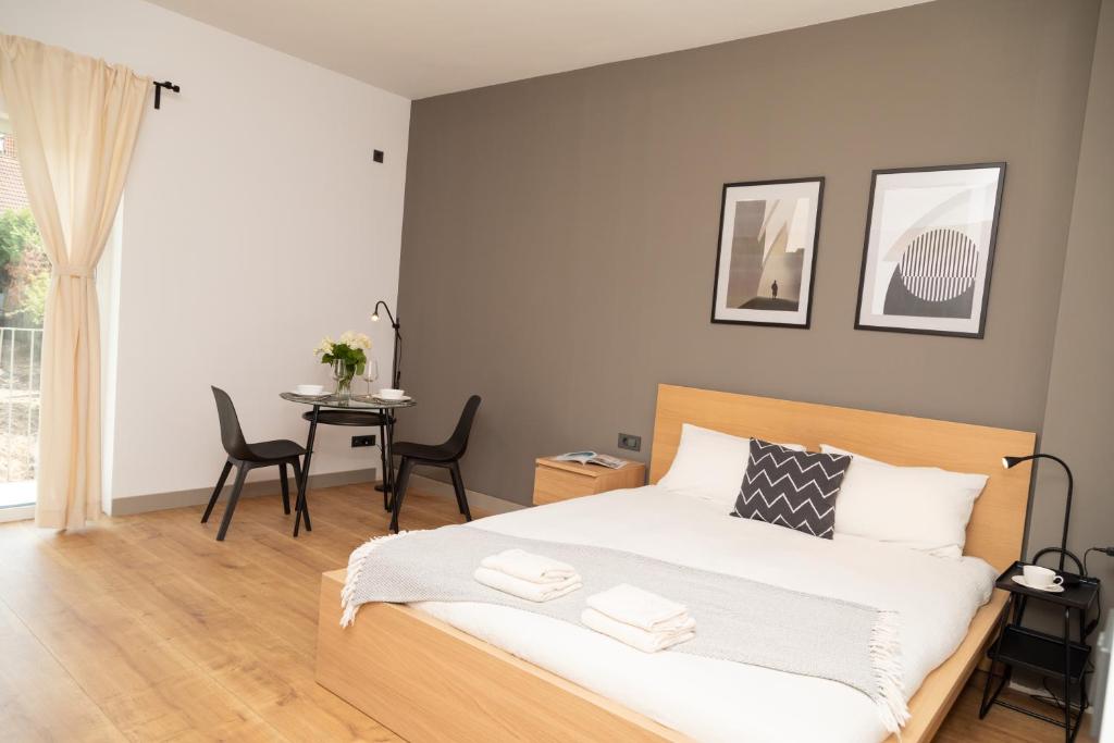 a bedroom with a bed and a table with chairs at SEKLER Apartments in Cluj-Napoca