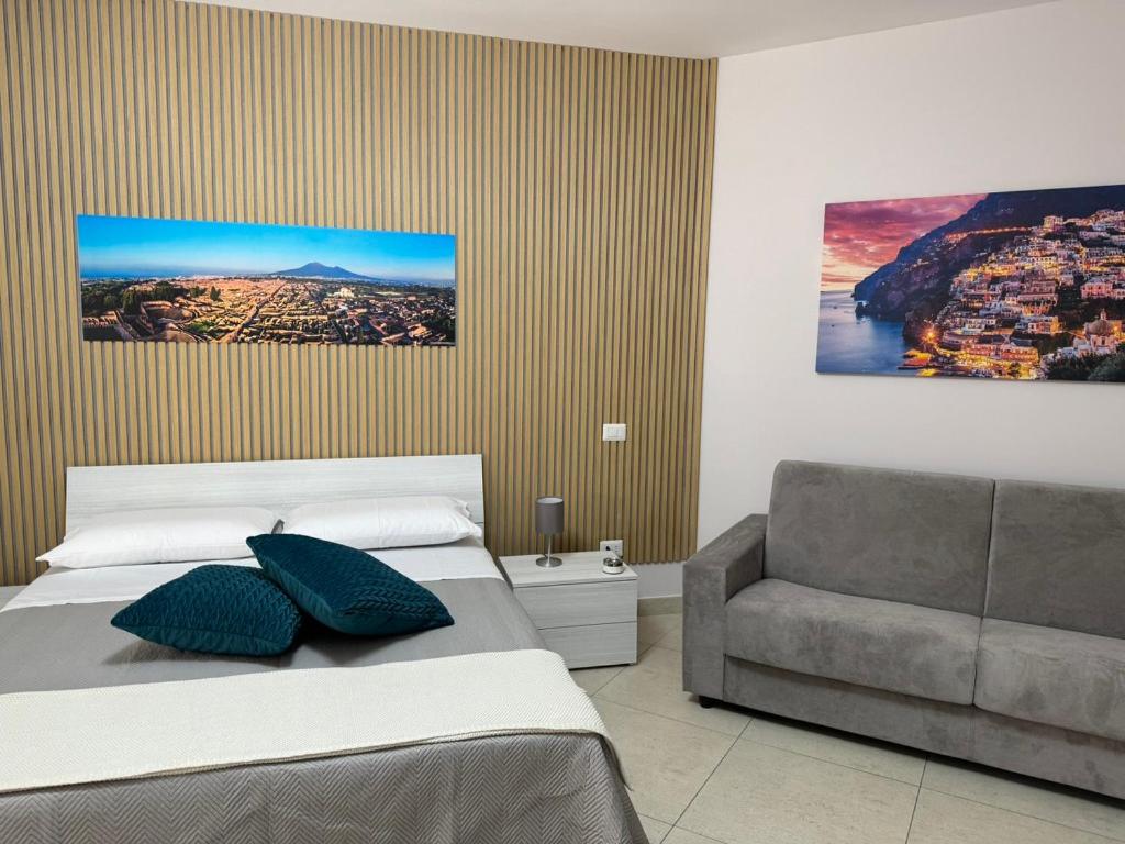 una camera da letto con un letto e un divano di Fabiria Guesthouse - B&B a Pagani