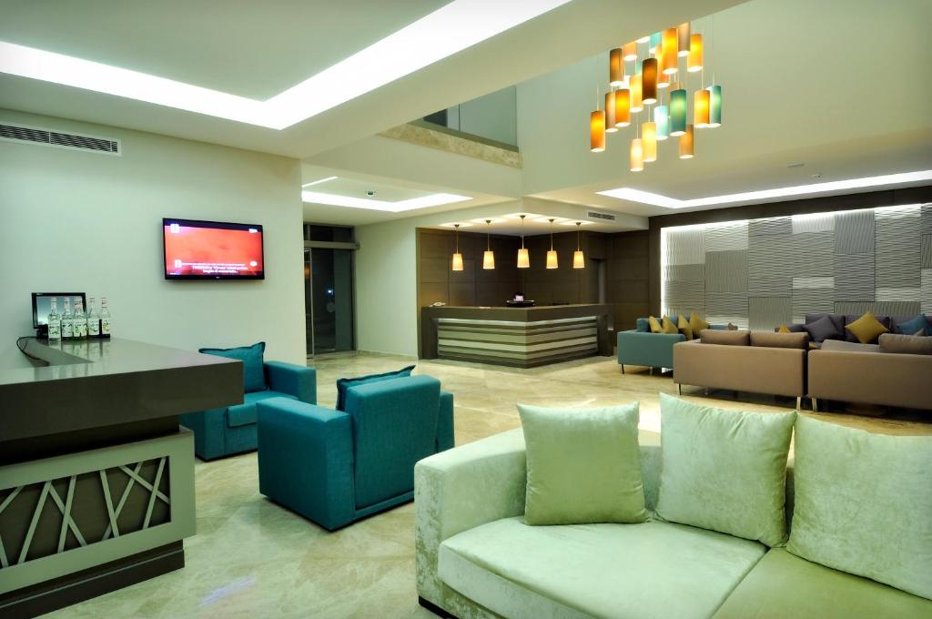a lobby with a couch and chairs and a tv at Lugga Boutique Hotel & Beach in Ortakent