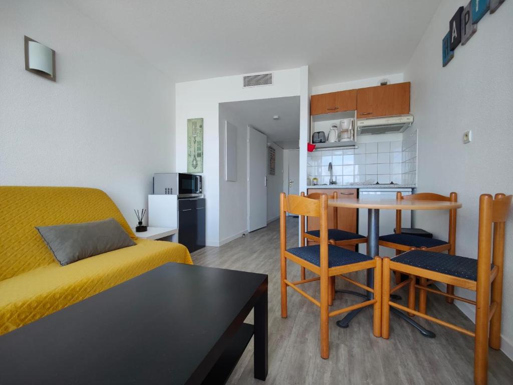 un salon avec un lit, une table et des chaises dans l'établissement L'Albatros- Parking - Piscine, à La Rochelle