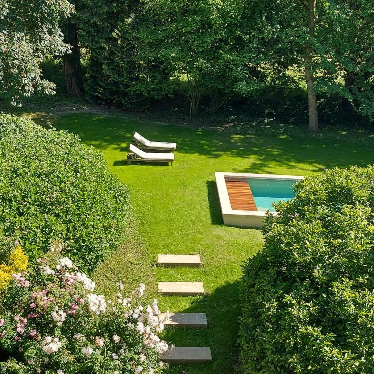 un jardin avec une piscine et un banc dans l'établissement Manoir de l'Angélus, à Dol-de-Bretagne