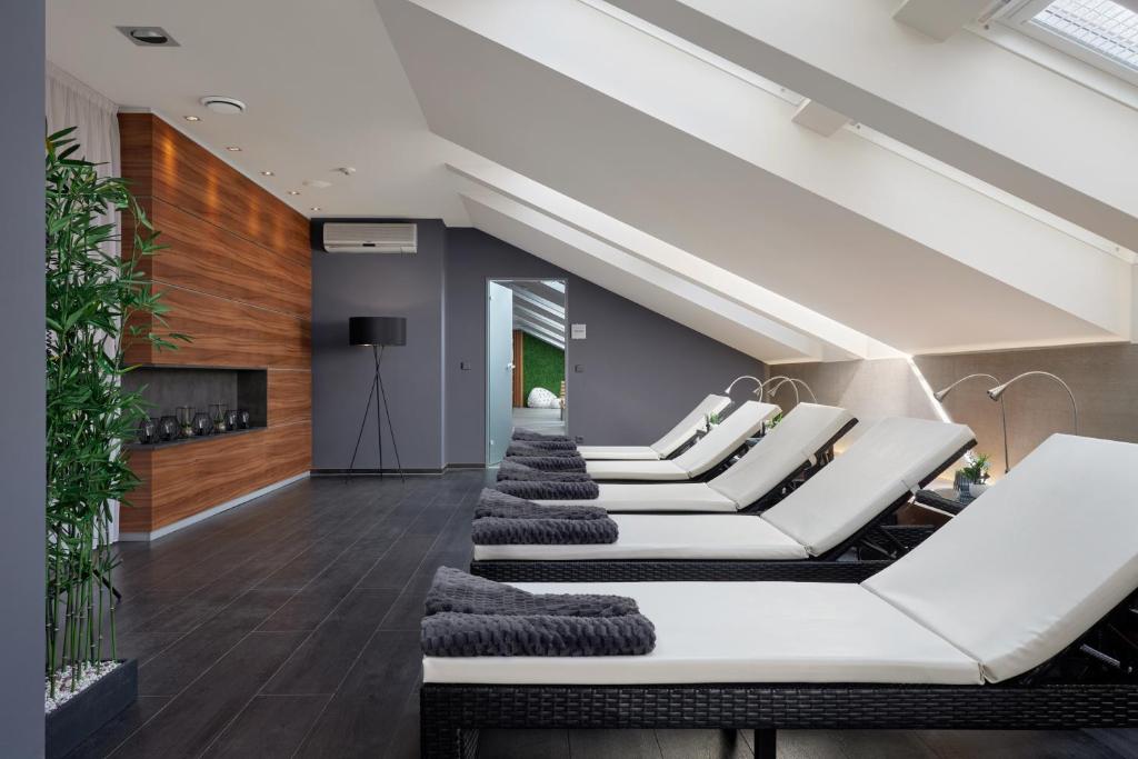 a living room with white furniture and wooden walls at Spa Hotel Felicitas in Poděbrady