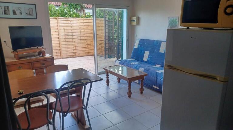 - un salon avec un canapé, une table et un réfrigérateur dans l'établissement Le Clos Do Ré, à Sainte-Marie de Ré