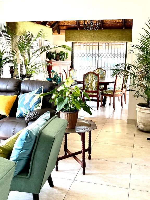 a living room with a couch and a table with plants at 76 On Crestwood in Sandton