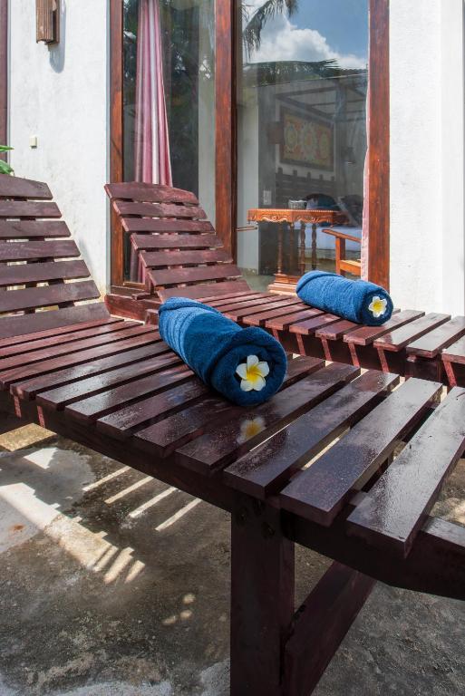 two blue pillows sitting on top of a wooden bench at Anama by Queens Mount in Tangalle