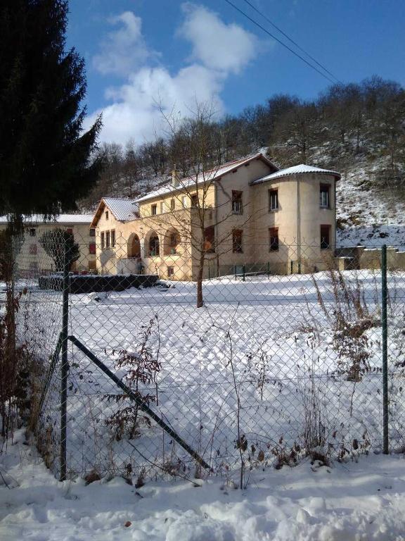 a house with a fence in the snow at Moulin de la Varenne in Saint-Saturnin