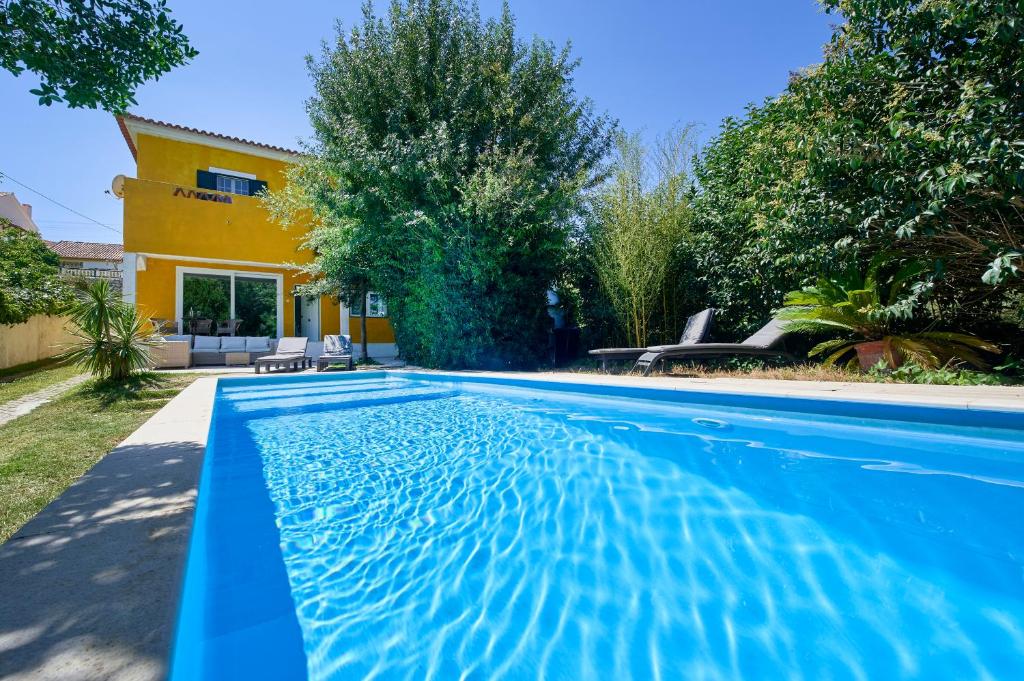 a swimming pool in front of a house at Beach & Nature Villa with Amazing Pool by TimeCooler in Setúbal