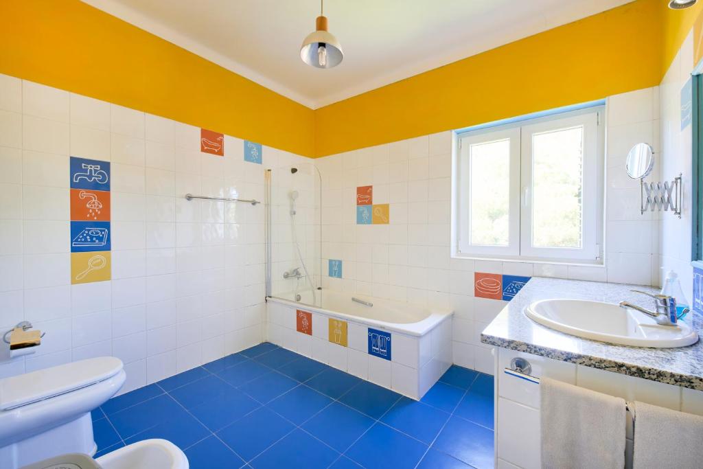 a bathroom with a sink and a tub and a toilet at Beach & Nature Villa with Amazing Pool by TimeCooler in Setúbal