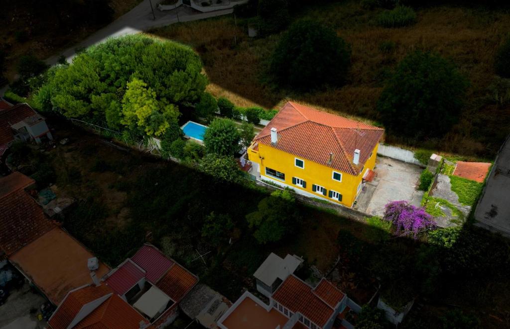 a yellow house with a red roof in a yard at Beach & Nature Villa with Amazing Pool by TimeCooler in Setúbal