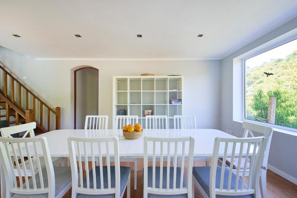 a dining room with a white table and chairs at Beach & Nature Villa with Amazing Pool by TimeCooler in Setúbal