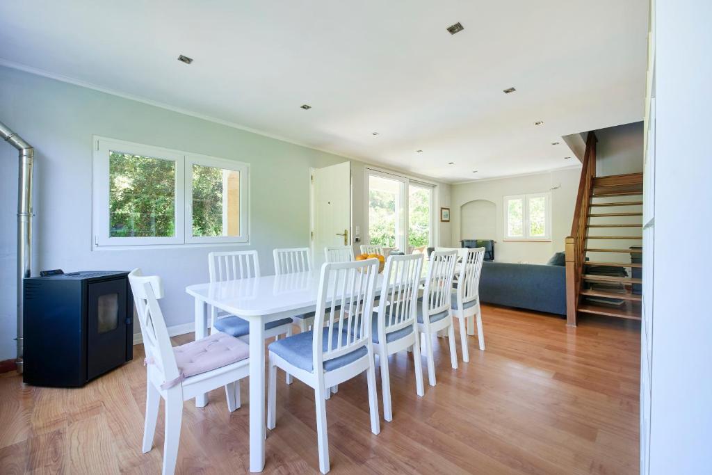 a dining room with a white table and chairs at Beach & Nature Villa with Amazing Pool by TimeCooler in Setúbal