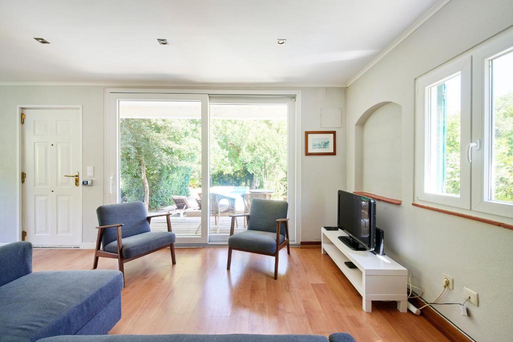 a living room with a couch and chairs and a tv at Beach & Nature Villa with Amazing Pool by TimeCooler in Setúbal
