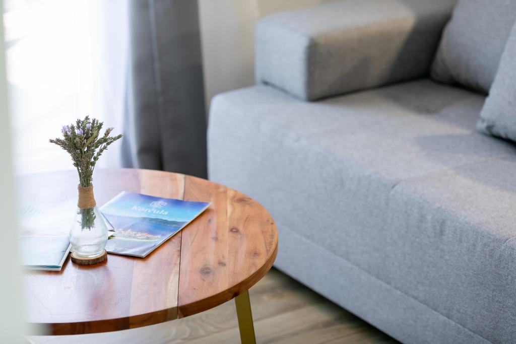 una mesa con un libro al lado de un sofá en Maloa One Bedroom 2, en Smokvica