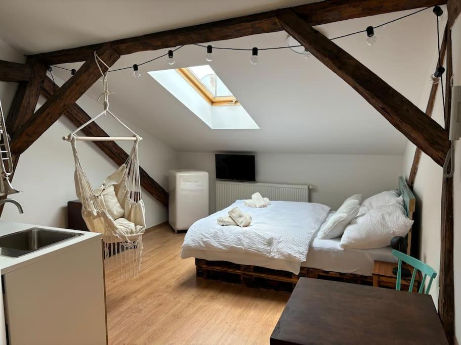 a bedroom with a bed and a hammock in a attic at Povala s parkovaním staré mesto in Žilina