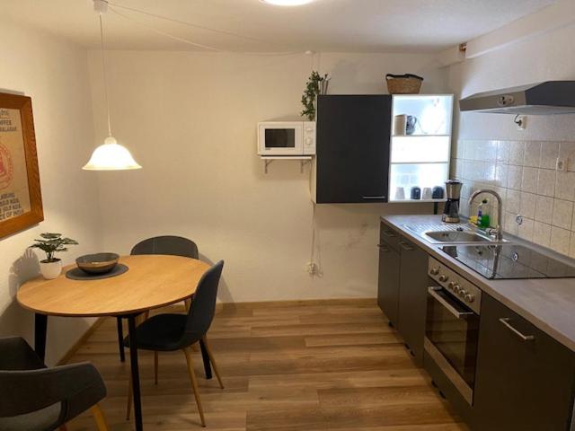y cocina con mesa, mesa pequeña y mesa. en Niederfischbach Ferienwohnung, en Niederfischbach