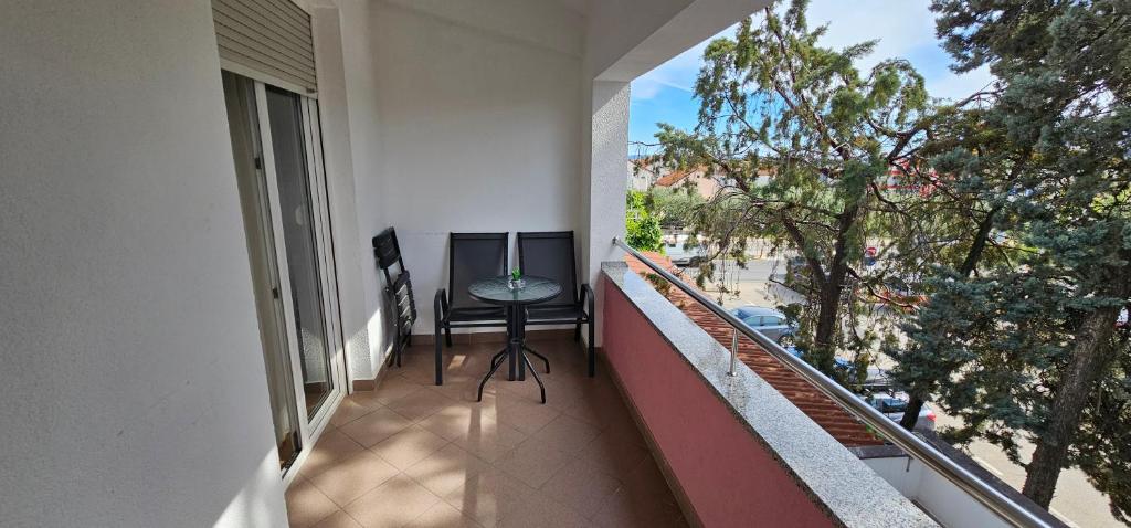 a balcony of a building with a chair and a window at SOBE/ROOMS RIVA in Zadar