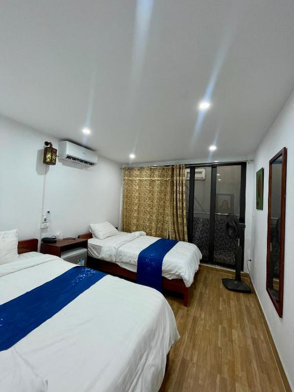a hotel room with two beds and a window at Agarwood in Hanoi
