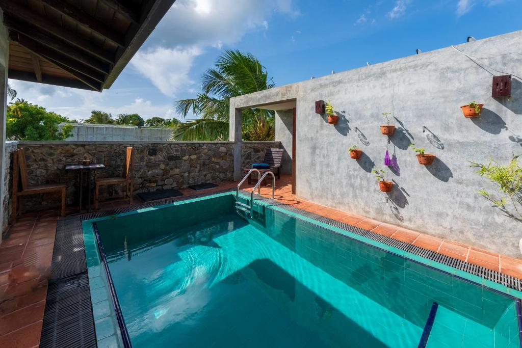 a swimming pool that is next to a building at Anama by Queens Mount in Tangalle