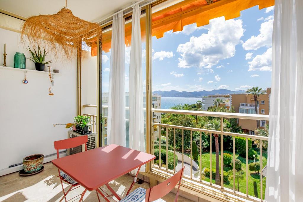 une pièce avec une table et une grande fenêtre dans l'établissement Cannes-vue mer Esterel-balcon-Plage, à Cannes