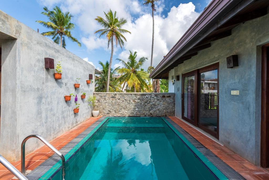 a swimming pool in the backyard of a house at Anama by Queens Mount in Tangalle