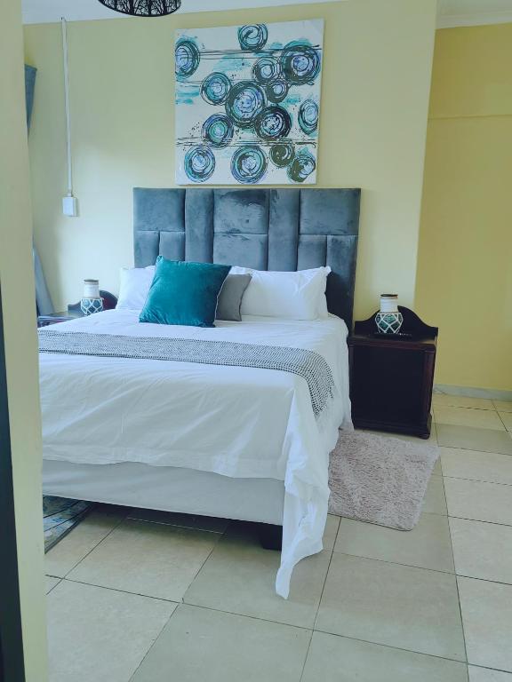 センチュリオンにあるChoosers Express Boutique Hotel Room 5のベッドルーム1室(大型ベッド1台、青と白の枕付)