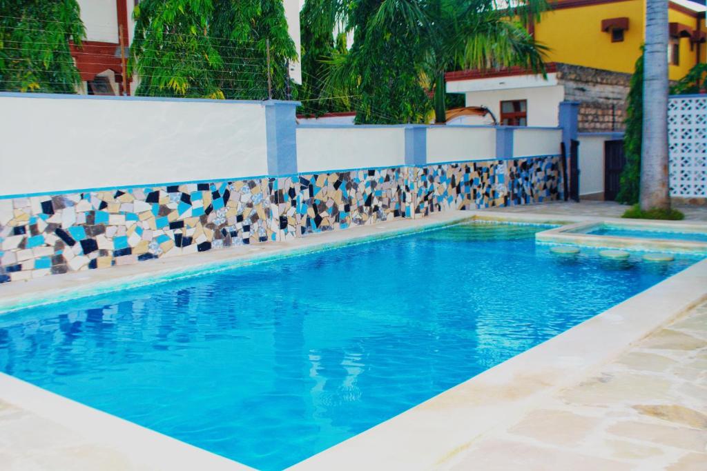 a swimming pool with blue water and a tile wall at Lulufurnishedapartments in Mombasa