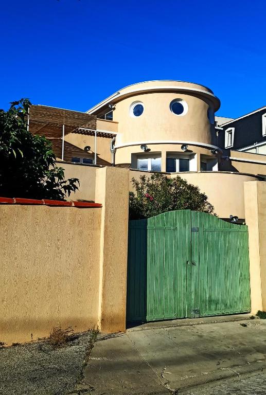 une maison avec un portail vert devant une clôture dans l'établissement Appartement 2 pièces à 150 m de la plage, à Marseille