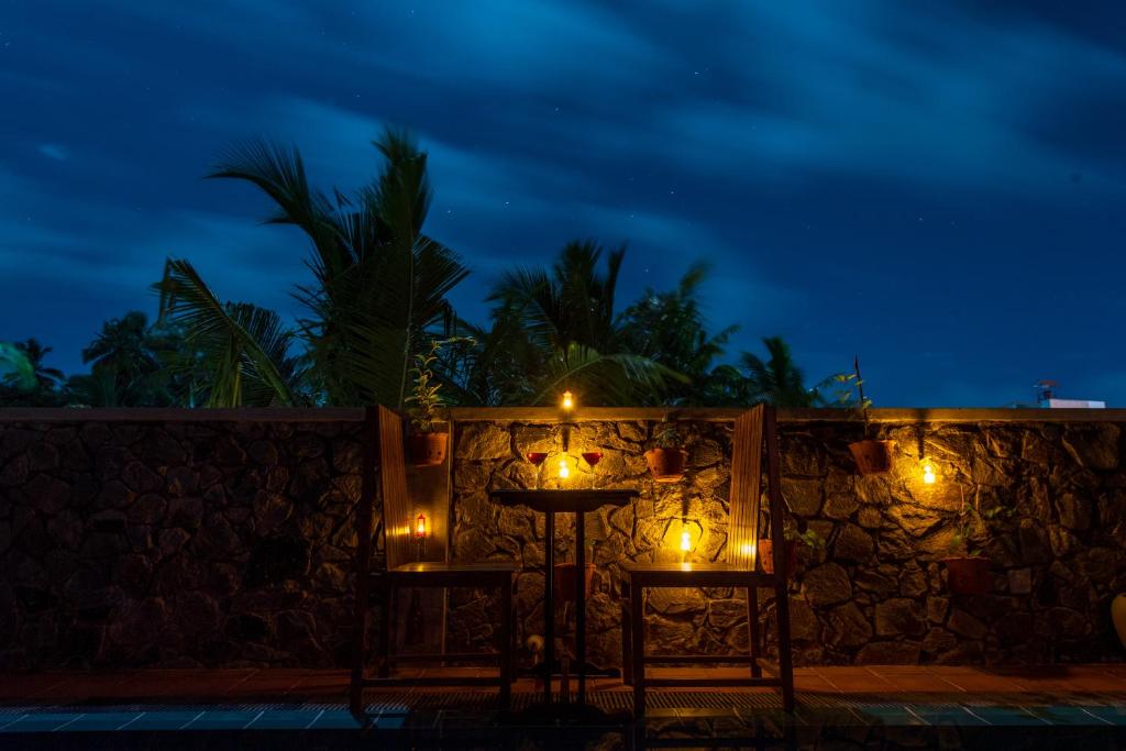 a stone wall with lights on it at night at Anama by Queens Mount in Tangalle
