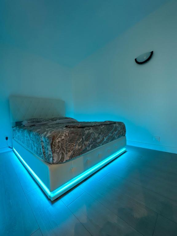Ce lit se trouve dans un dortoir doté de lumières bleues. dans l'établissement Appartement à Ris Orangis, à Ris-Orangis