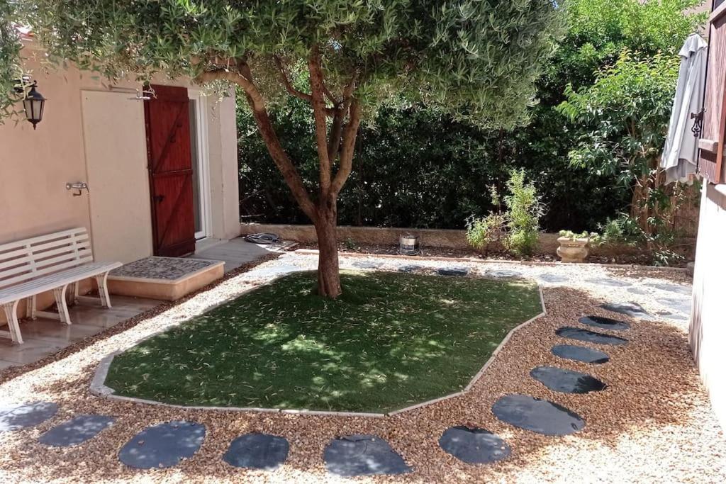 un arbre au milieu d'une cour avec du gravier dans l'établissement Bas de Villa 