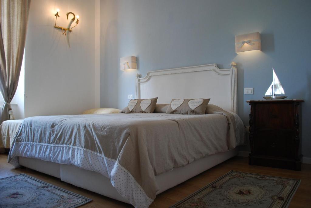 1 dormitorio con 1 cama grande y cabecero blanco en Piccolo Navy, en Livorno