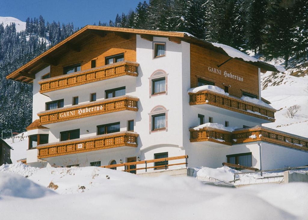 un grande edificio con neve di fronte di Hubertus Appartements a Ischgl