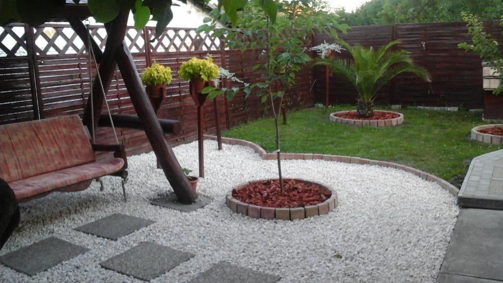 a garden with a couch and trees in a yard at Andi Apartman in Gyula