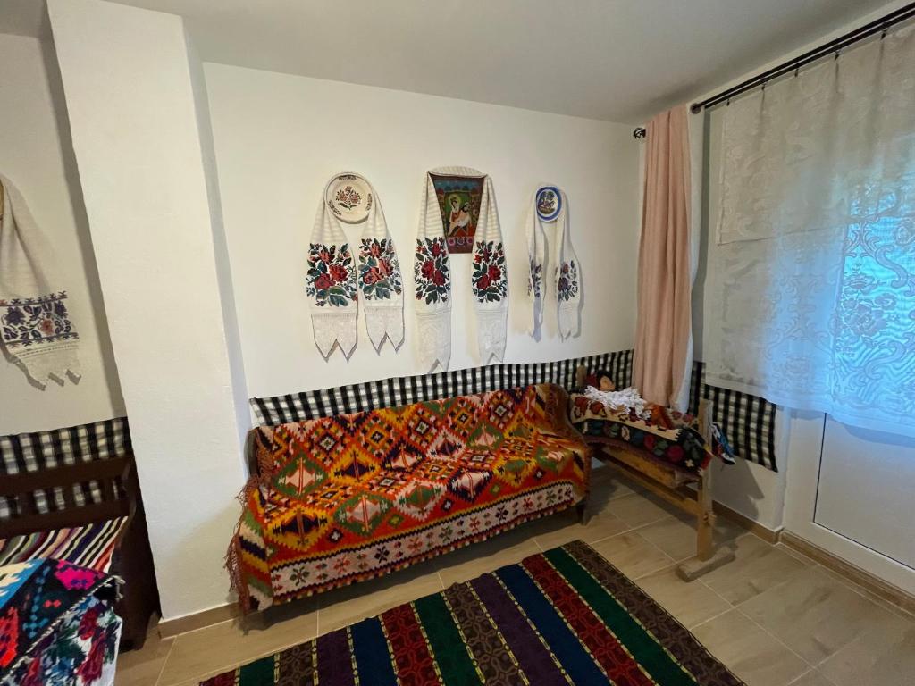a living room with a couch and decorations on the wall at Casa familiala de vacanta in Bogdan Vodă