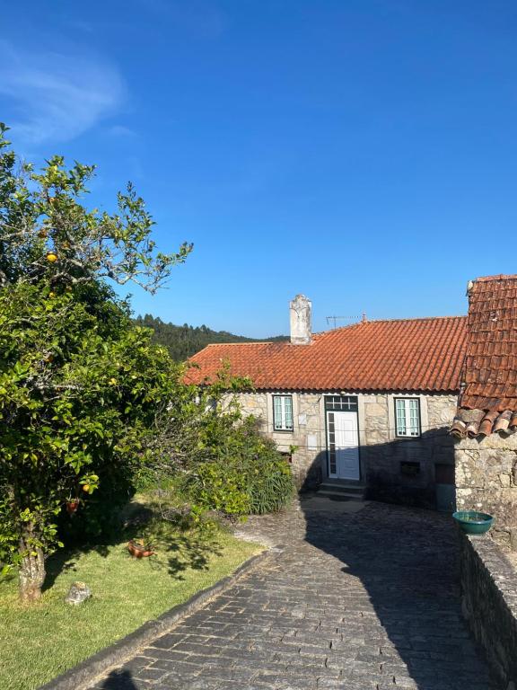 een stenen huis met een rood dak en een oprit bij Casa do Carqueijo in Vila Praia de Âncora