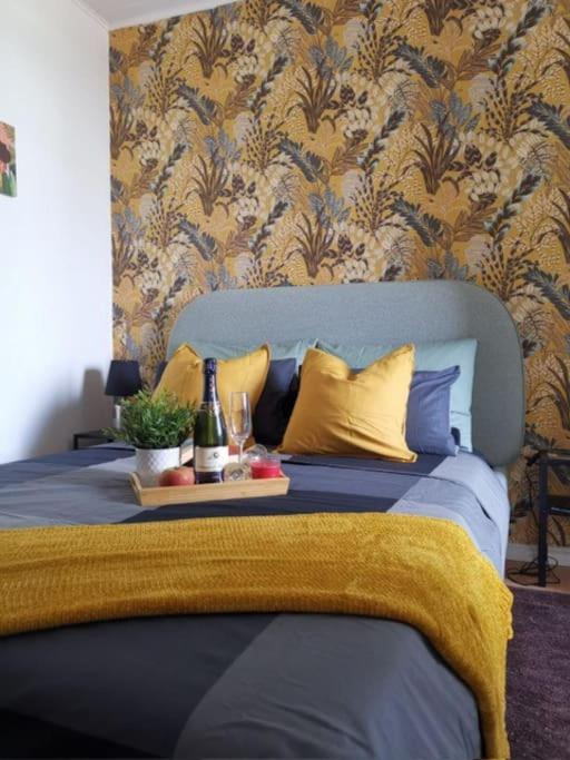 - un lit avec une couette bleue et des oreillers jaunes dans l'établissement mulhouse hyper centre, à Mulhouse