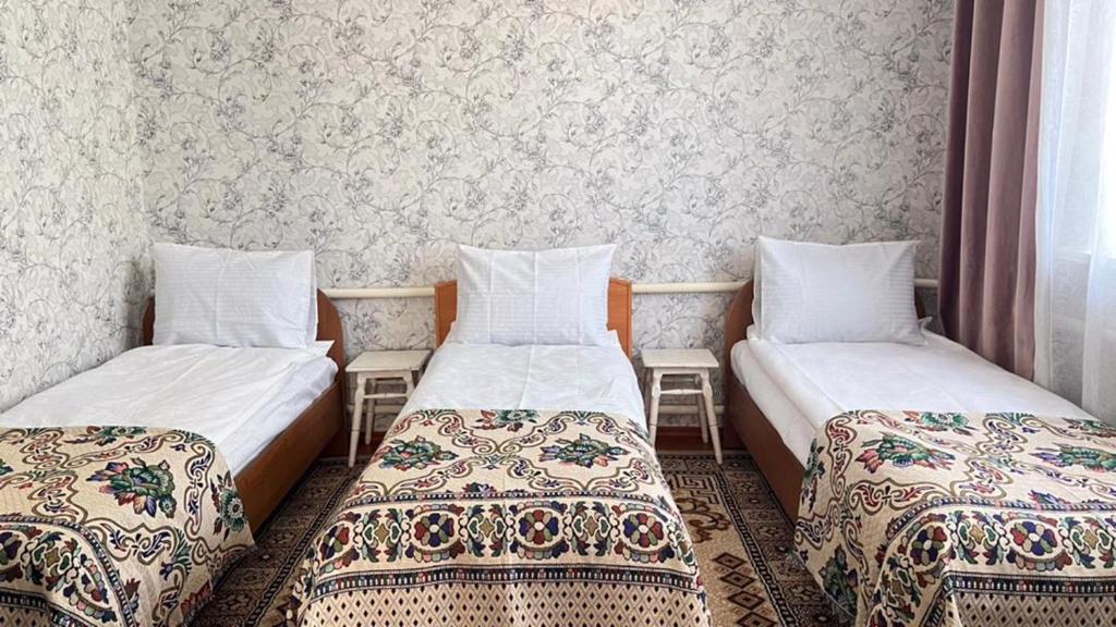 a room with two beds and a wall at Panphilove 23 in Cholpon-Ata