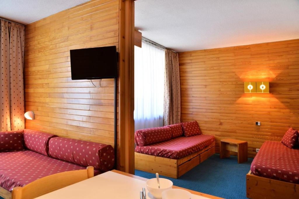 une chambre d'hôtel avec deux canapés et une télévision dans l'établissement Résidence Saint Jacques A - Studio pour 4 Personnes 19, à Mâcot La Plagne